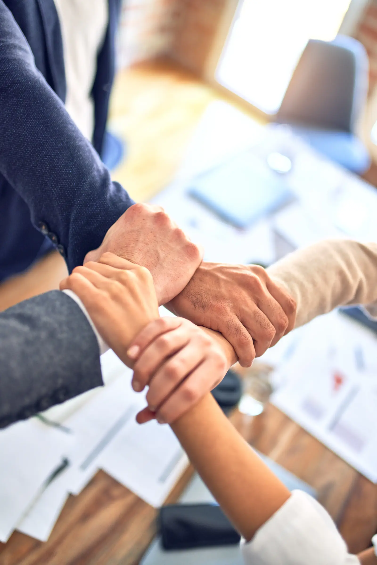 Warm welcome handshake at a desk — new hire being onboarded